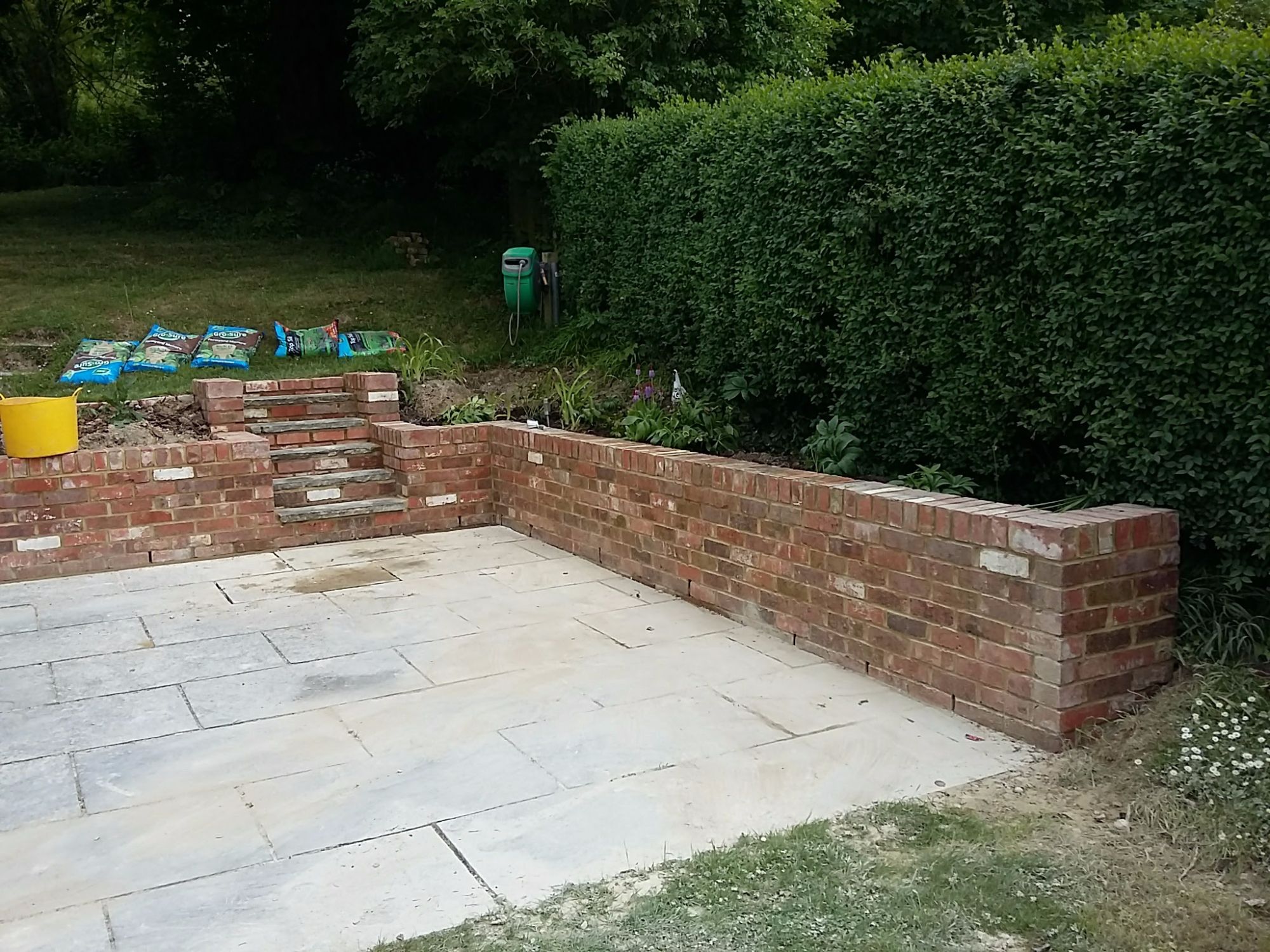 Stone paved patio and brick retaining wall